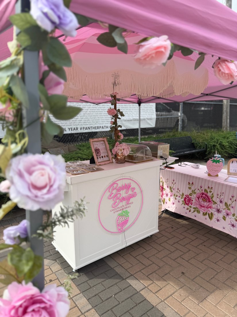 Berry Bougie tent decorated with pink and lavender roses at an outdoor festival