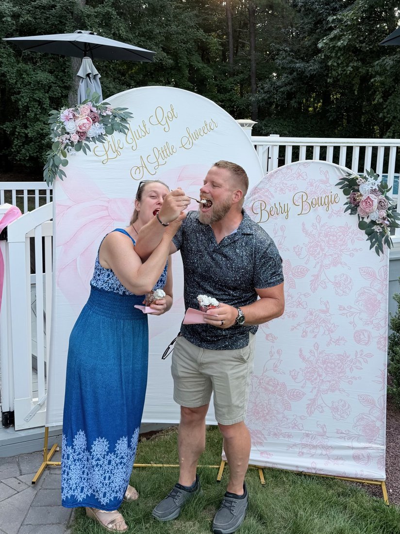 Guests feeding each other chocolate drizzled strawberries at the Berry Bougie backdrop