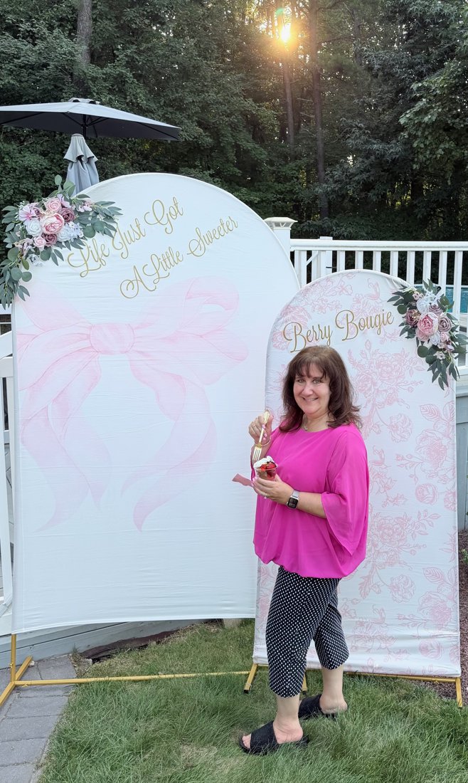 Guest holding a Berry Bougie strawberry cup at the event backdrop