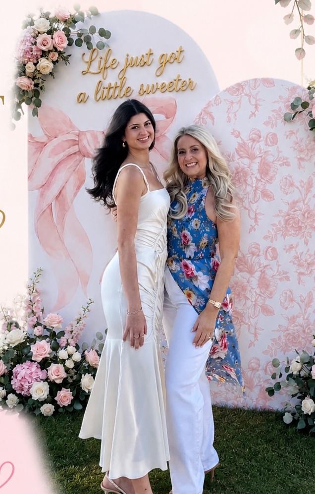 Berry Bougie founders in front of a floral event backdrop